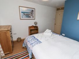 A bedroom with a bed and dresser at Elford Farmhouse Seahouses