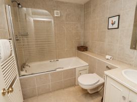 A bathroom with a bathtub and a toilet at Elford Farmhouse Seahouses