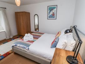 A bedroom with a bed and wardrobe at Elford Farmhouse in Seahouses