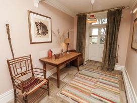 A hallway with a table and chair at Elford Farmhouse in Seahouses