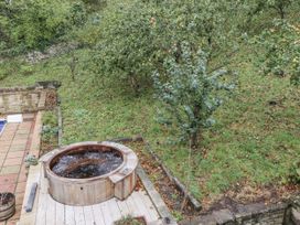 A garden with a hot tub and trees at Elford Farmhouse in Seahouses