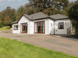 A house with large windows and a driveway at The Lodge in Bridgend