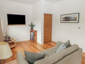 A living room with a sofa and television at The Lodge in Bridgend
