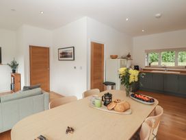 A kitchen and dining area with a table and chairs at The Lodge in Bridgend