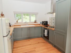 A kitchen with cabinets, a sink, and a refrigerator at The Lodge in Bridgend