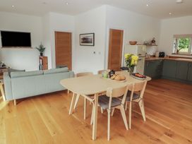 An open plan living area with a dining table and kitchen at The Lodge in Bridgend