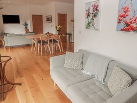 A living room with a sofa and dining area at The Lodge in Bridgend
