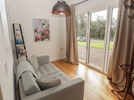 A living room with a sofa and a shelf at The Lodge in Bridgend