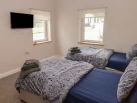 A bedroom with two beds and a television at The Lodge in Bridgend