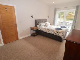 A bedroom with a bed and bedside table at The Lodge in Bridgend