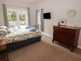 A bedroom with a bed and a dresser at The Lodge in Bridgend