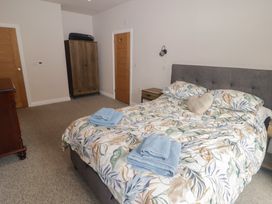 A bedroom with a bed and wardrobe at The Lodge in Bridgend