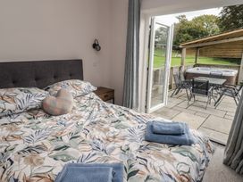 A bedroom with a bed and sliding doors leading to a patio at The Lodge in Bridgend