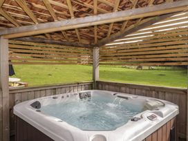 A hot tub in a wooden structure in an outdoor area at The Lodge in Bridgend