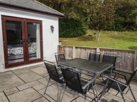 A patio area with a table and chairs at The Lodge in Bridgend