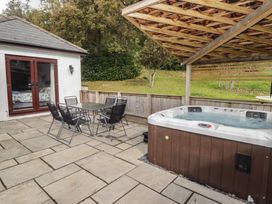 An outdoor space with a jacuzzi and seating area at The Lodge in Bridgend