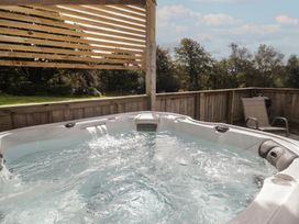 A hot tub on a deck at The Lodge in Bridgend