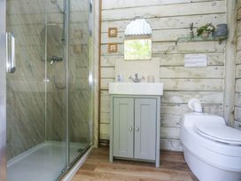 A bathroom with a shower enclosed in glass a sink cabinet and a toilet at Sika in Warmwell