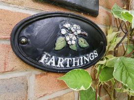 A Farthings plaque on a brick wall at Farthings, Weymouth