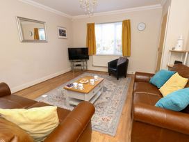 A living room with a television and coffee table at Farthings in Weymouth