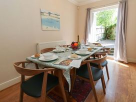 A dining room with a table set for meals at Farthings in Weymouth