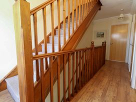A hallway with stairs and a door at Farthings in Weymouth
