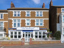 A three story brick building with white trimmed windows and a sign reading The Burleigh in Hunstanton