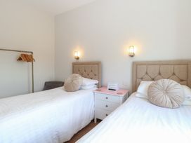 A bedroom with two single beds separated by a white nightstand at The Burleigh in Hunstanton