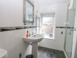 A bathroom with a pedestal sink mirror window and a glass shower enclosure at The Burleigh in Hunstanton