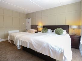 A bedroom with two beds a bedside table and lamps at The Burleigh in Hunstanton
