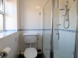 A bathroom with a toilet and a glass shower enclosure at The Burleigh in Hunstanton