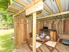 An outdoor wooden shelter with a dining table set with plates and glasses and a wooden sign reading Stardust at Stardust in Ventnor