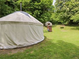 Two round tents in a grassy area with trees in the background at Stardust in Ventnor