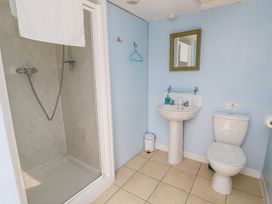 A bathroom with a shower, sink, toilet, mirror, and towel hanging with light blue walls at Stardust in Ventnor