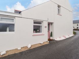 An exterior view of a house with a pink door at Penwyn in Solva