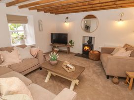 A living room with a sofa and television at Penwyn in Solva