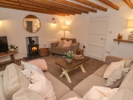 A living room with a sofa and fireplace at Penwyn in Solva