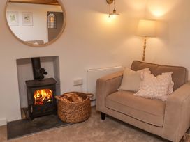 A living room with an armchair and a fireplace at Penwyn in Solva
