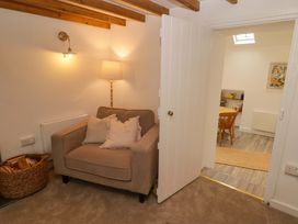 A living room with a chair and a door at Penwyn in Solva