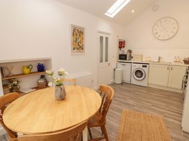 A kitchen with a table and chairs and appliances at Penwyn in Solva