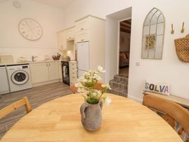 A kitchen with a dining table and washing machine at Penwyn Solva