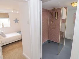 A bedroom with a bed and a shower area at Penwyn in Solva