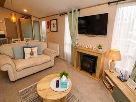 A living room with a sofa and TV at Seren in Broughton, Cumbria