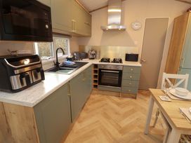 A kitchen with appliances and a dining table at Seren in Broughton, Cumbria