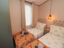 A bedroom with two beds and towels on them at Seren in Broughton, Cumbria