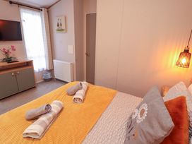 A bedroom with a bed and towels on it at Seren in Broughton, Cumbria