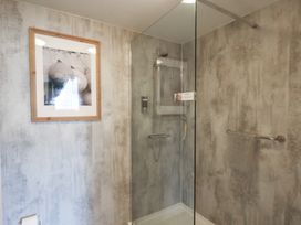 A bathroom with a glass shower enclosure a framed picture on the wall and a towel rack at Flat 2 The Old Chapel in Whitby