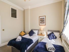 A bedroom with two single beds side by side with blue blankets and pillows at Flat 2 The Old Chapel in Whitby
