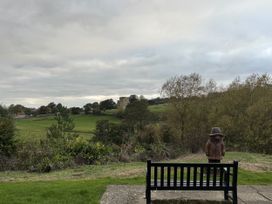 A bench and statue overlooking a field at 32 Castlegate East Ayton