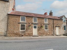 A house with windows and flowers at Kingfisher Cottage in East Ayton
